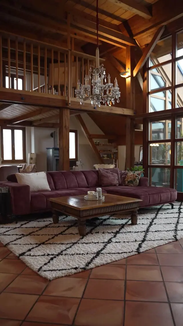 Wohnraum mit Kristallluster und Bordeaux-Sofa