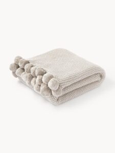 Strickdecke Molly mit Pompoms in beige, 130 x 170 cm, ideal für gemütliche Abende und Wohnaccessoires.