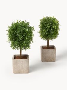 Handgefertigter Kunstbaum Moni dekoriert mit weißen Kieselsteinen in einem stilvollen Übertopf